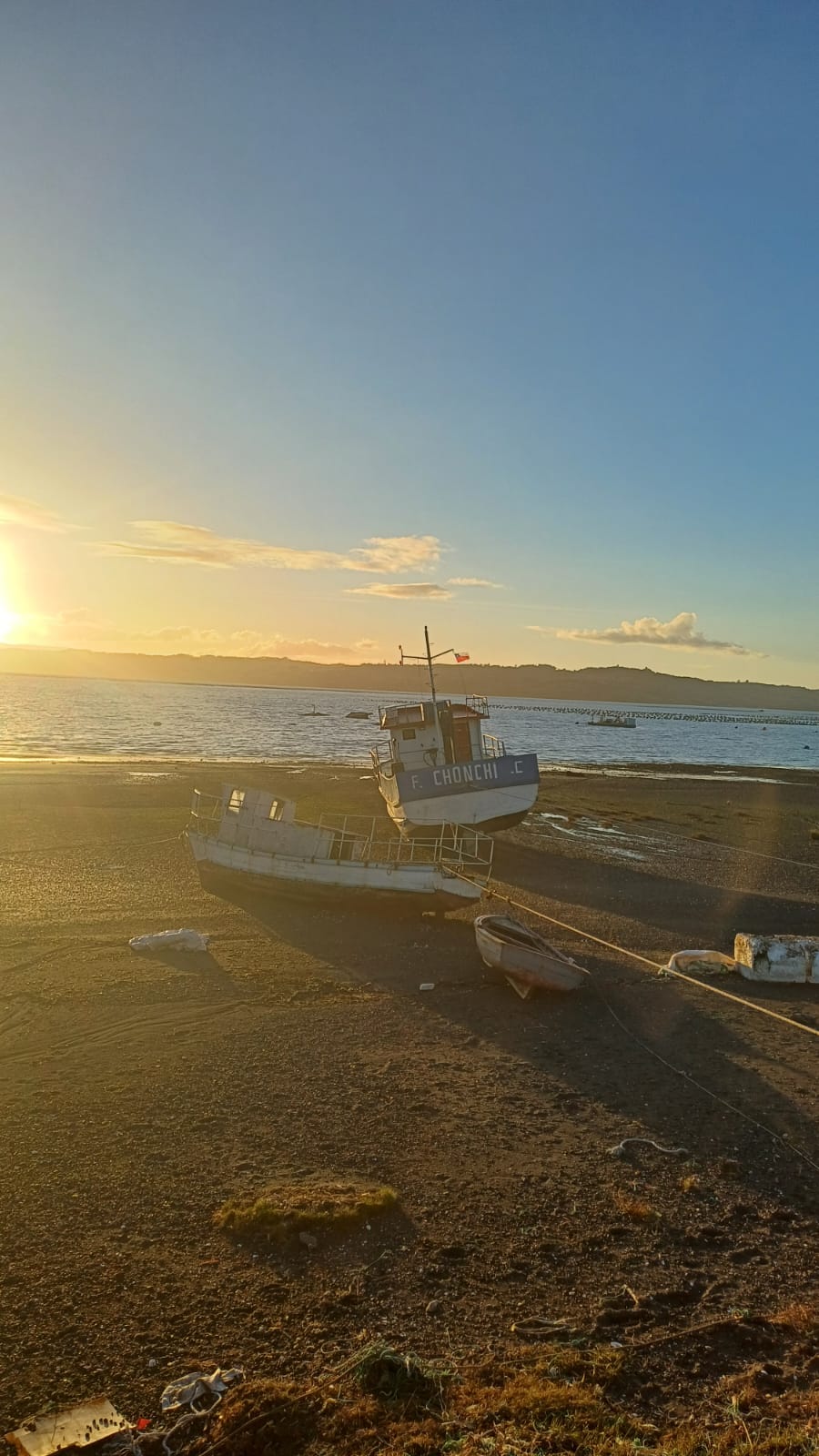 Embarcación F. Chonchi en la playa al atardecer con vista al mar